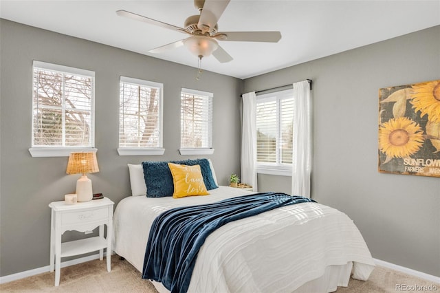 bedroom featuring light carpet, ceiling fan, and baseboards