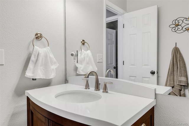 bathroom featuring a textured wall and vanity