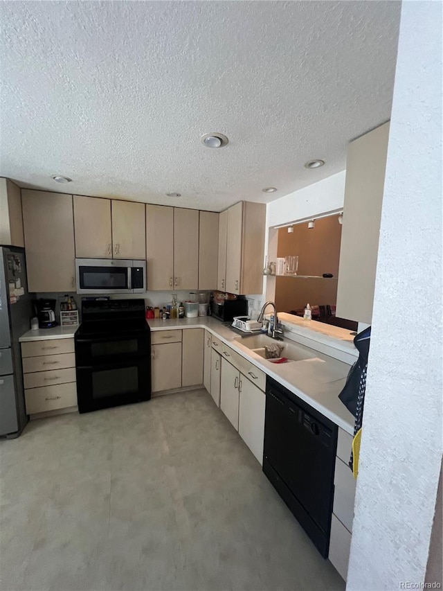 kitchen featuring black appliances, a sink, light countertops, and a textured ceiling