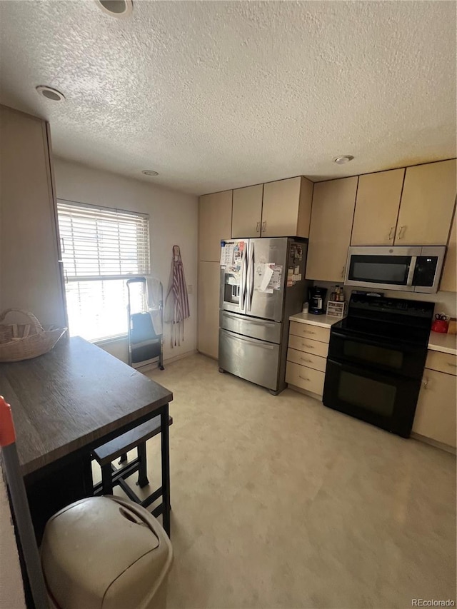 kitchen featuring stainless steel appliances, a textured ceiling, light carpet, and light countertops