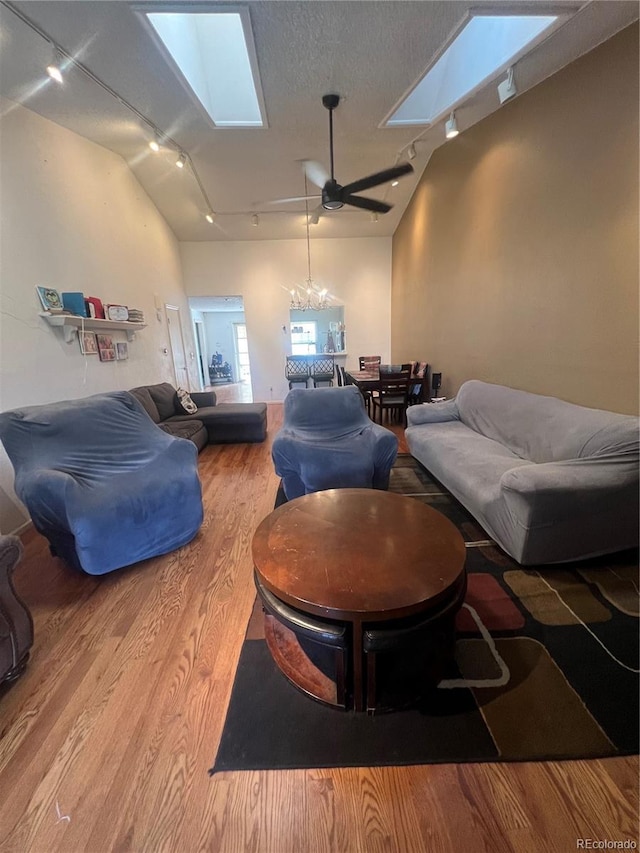 living room with track lighting, a skylight, wood finished floors, and ceiling fan