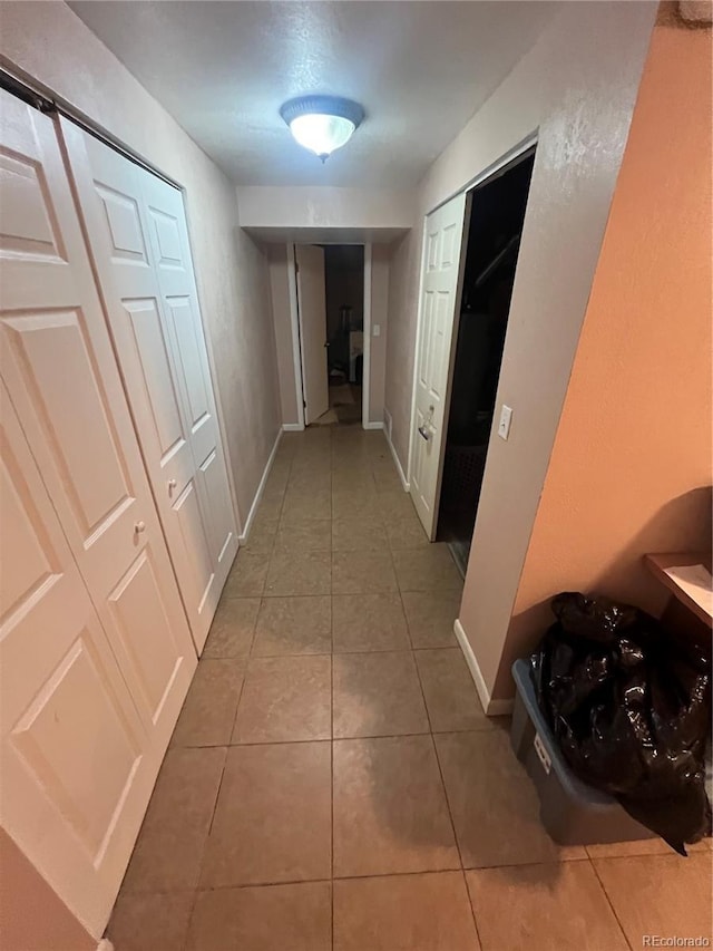 corridor with tile patterned flooring and baseboards