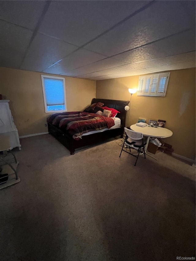 carpeted bedroom featuring a paneled ceiling and baseboards