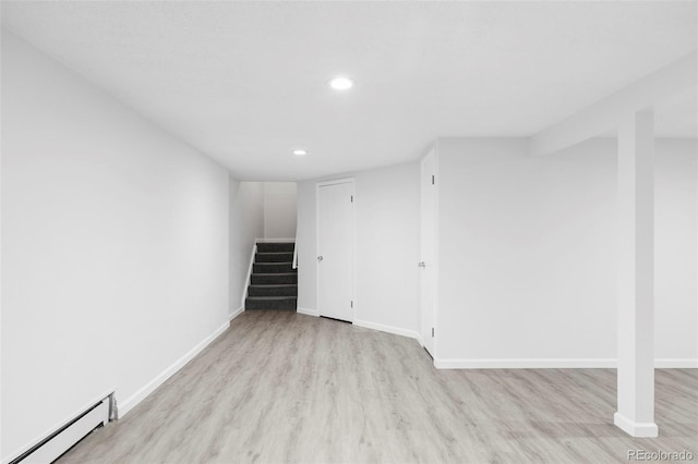 6982 Estes Dr, Arvada, CO 80004 - finished below grade area with a baseboard radiator, recessed lighting, wood finished floors, stairway, and baseboards
