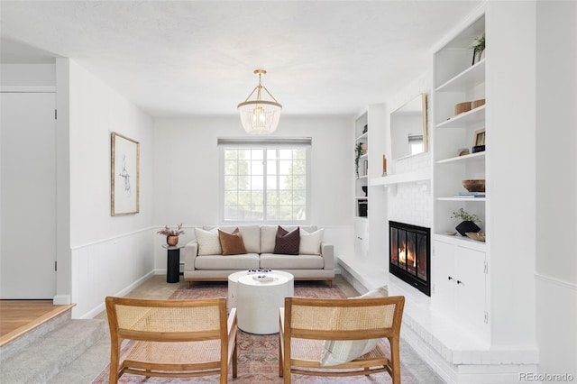 6982 Estes Dr, Arvada, CO 80004 - living area featuring a glass covered fireplace, built in features, and a chandelier