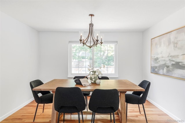 6982 Estes Dr, Arvada, CO 80004 - dining area featuring light wood-style flooring, a chandelier, and baseboards