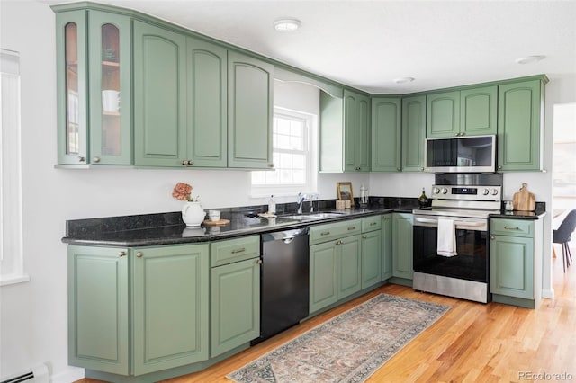 6982 Estes Dr, Arvada, CO 80004 - kitchen featuring appliances with stainless steel finishes, baseboard heating, a sink, and light wood-style floors