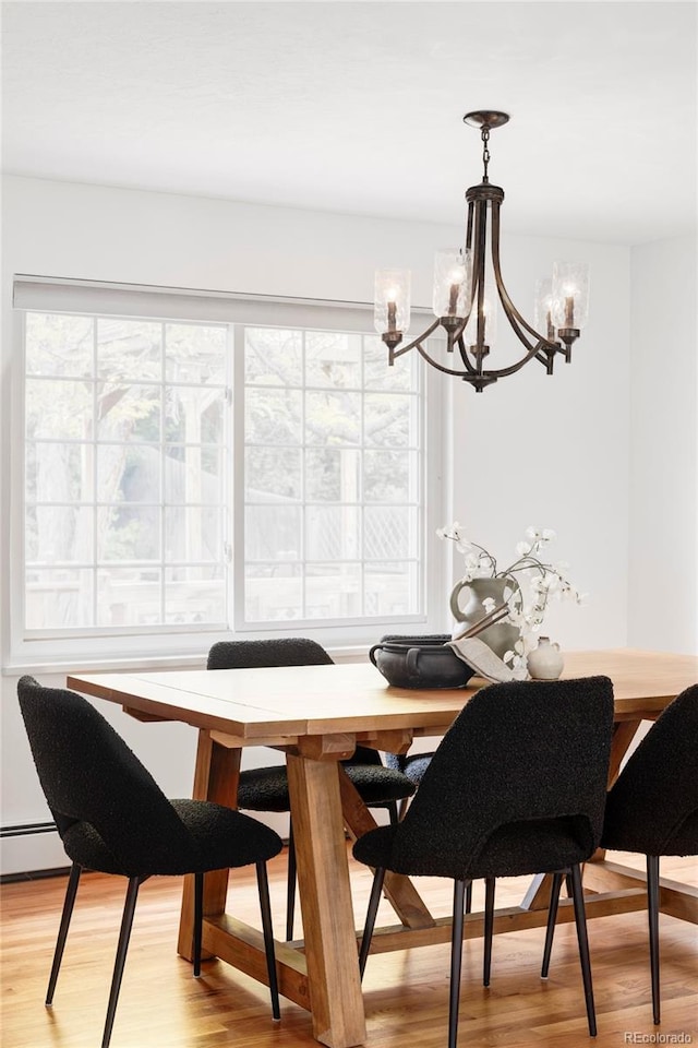 6982 Estes Dr, Arvada, CO 80004 - dining space with a chandelier, plenty of natural light, light wood-style floors, and a baseboard radiator