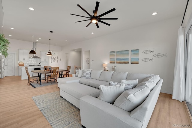 living room featuring ceiling fan and light hardwood / wood-style flooring