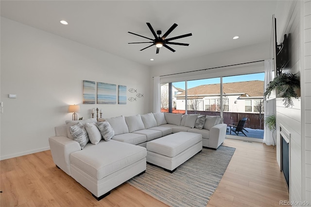 living room featuring a mountain view, light hardwood / wood-style flooring, and ceiling fan