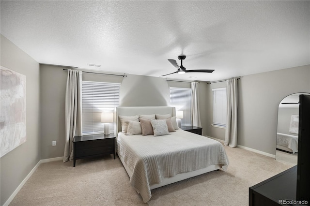 carpeted bedroom featuring a textured ceiling and ceiling fan