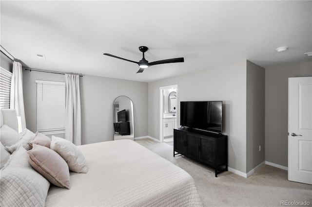 bedroom with light colored carpet, ceiling fan, and ensuite bathroom