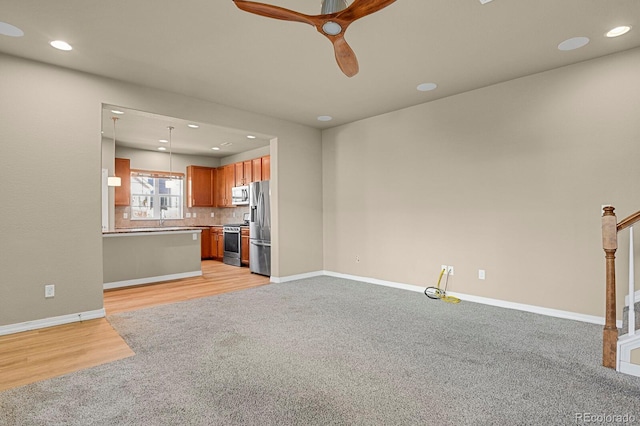 unfurnished living room with light hardwood / wood-style flooring and ceiling fan