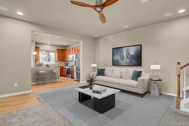 living room featuring light hardwood / wood-style floors and ceiling fan