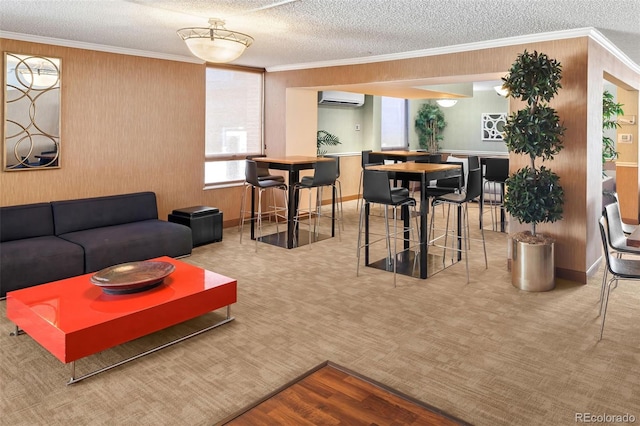 carpeted living room featuring a textured ceiling, ornamental molding, baseboards, and a wall mounted AC