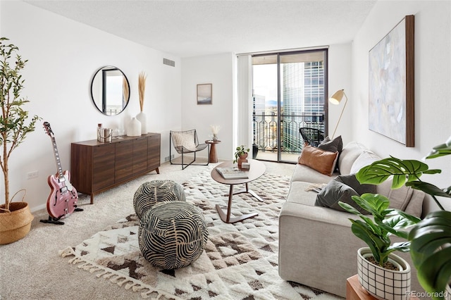 living area with carpet flooring, floor to ceiling windows, a textured ceiling, and visible vents