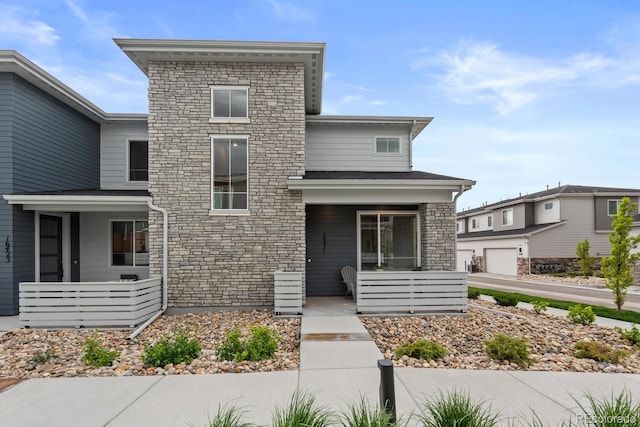 contemporary home with a porch and stone siding