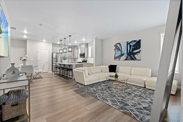 living area with light wood finished floors and recessed lighting