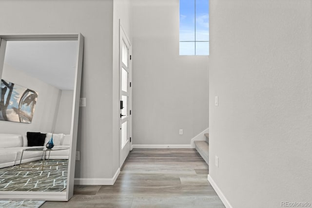foyer with stairway, wood finished floors, and baseboards