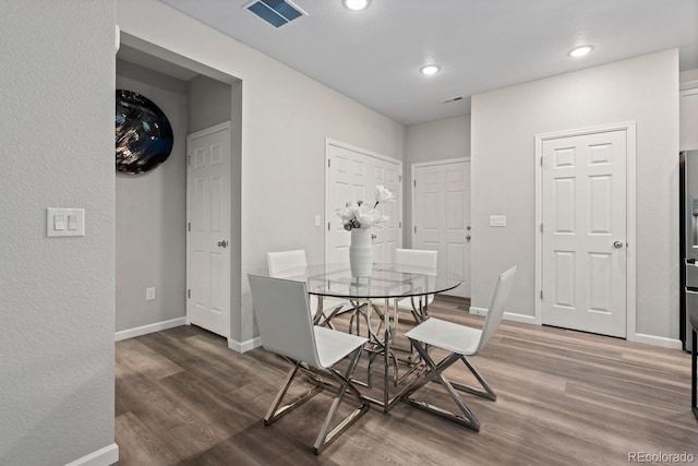 dining space with wood finished floors, baseboards, and recessed lighting