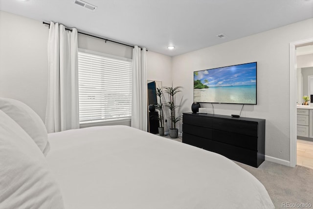 bedroom with carpet floors, baseboards, and connected bathroom