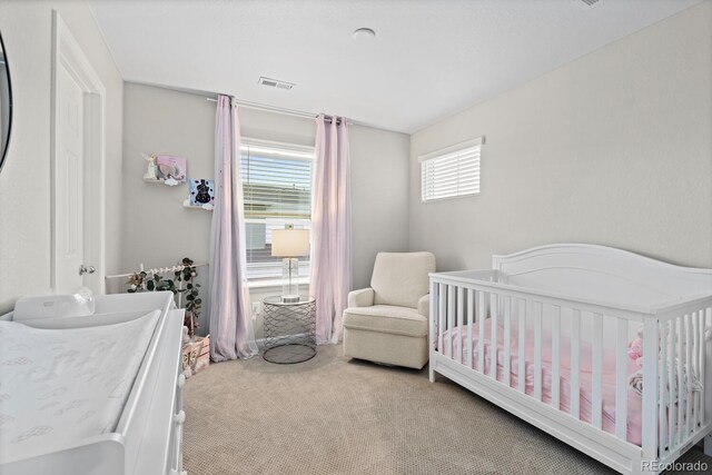 carpeted bedroom with a crib
