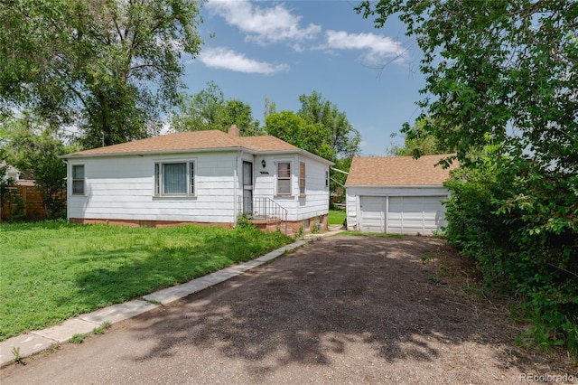2665 W College Ave, Denver, CO 80219 - view of front facade with an outbuilding, a chimney, a garage, a front lawn, and a shingled roof