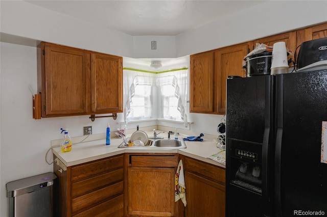 2665 W College Ave, Denver, CO 80219 - kitchen with black refrigerator with ice dispenser, light countertops, and brown cabinets