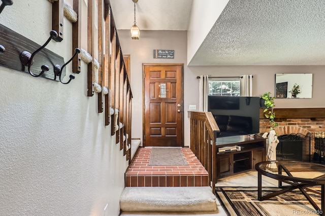 2072 S Helena St Unit B, Aurora, CO 80013 - entrance foyer with a brick fireplace, stairway, a textured ceiling, and a textured wall