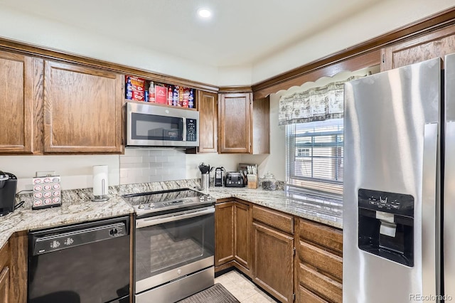 2072 S Helena St Unit B, Aurora, CO 80013 - kitchen featuring stainless steel appliances, light tile patterned floors, brown cabinetry, and light stone counters