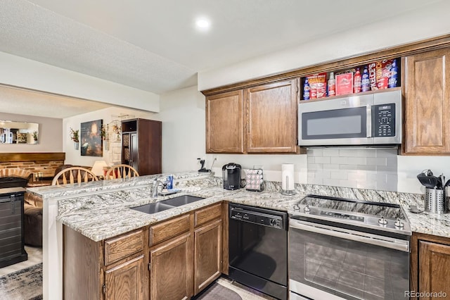 2072 S Helena St Unit B, Aurora, CO 80013 - kitchen featuring a peninsula, appliances with stainless steel finishes, light stone counters, backsplash, and brown cabinetry