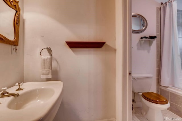 full bathroom with shower / tub combo, a sink, toilet, and tile patterned floors