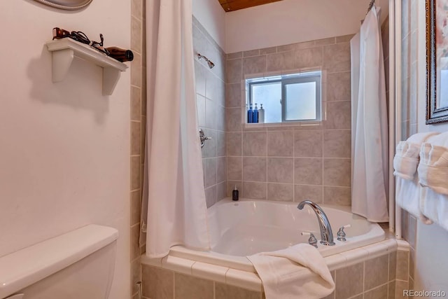 full bathroom featuring tiled shower / bath combo and toilet