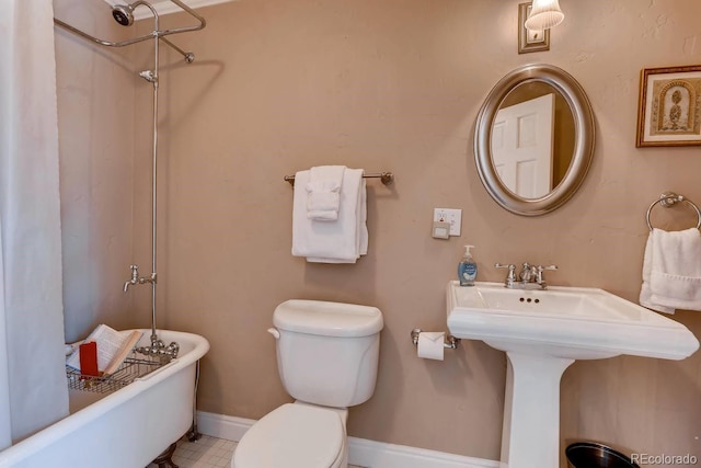 full bathroom with baseboards, a shower, toilet, a tub, and a sink