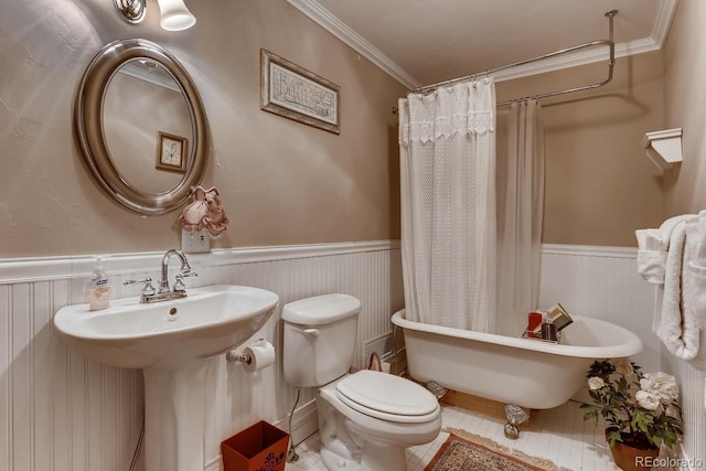 full bath featuring a wainscoted wall, ornamental molding, and a soaking tub