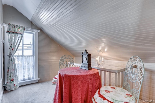 carpeted bedroom featuring lofted ceiling and an inviting chandelier