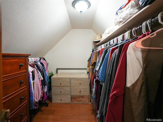 walk in closet featuring lofted ceiling and wood finished floors