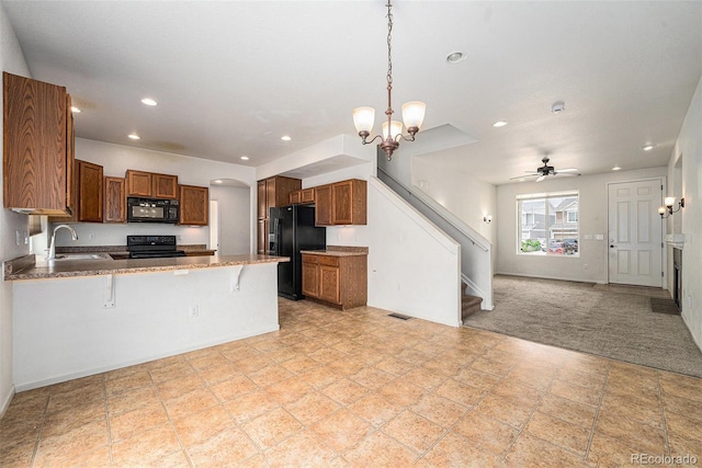 5572 Killarney St, Denver, CO 80249 - kitchen featuring black appliances, open floor plan, brown cabinets, a peninsula, and recessed lighting