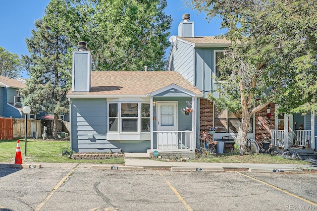 8168 Washington St Unit 46, Denver, CO 80229 - view of front of house with a chimney, uncovered parking, and brick siding