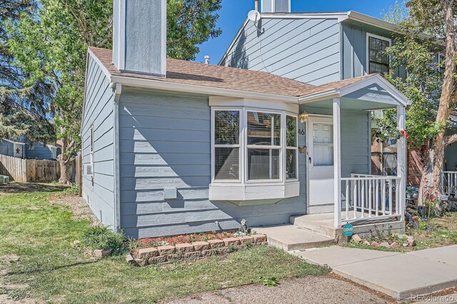8168 Washington St Unit 46, Denver, CO 80229 - view of property exterior featuring a chimney and a shingled roof