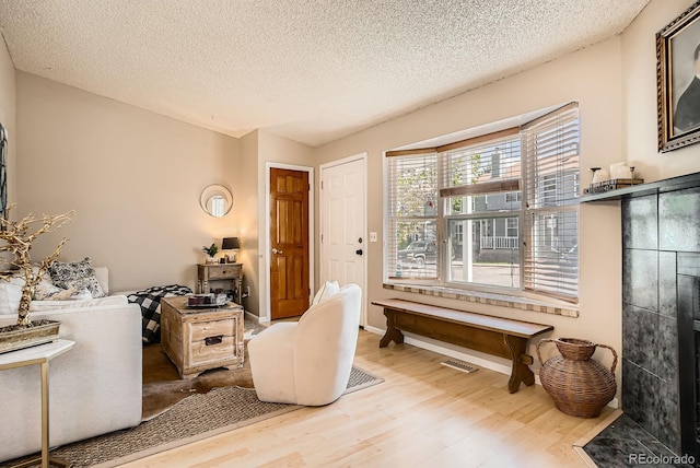 8168 Washington St Unit 46, Denver, CO 80229 - living area with wood finished floors, a textured ceiling, and baseboards