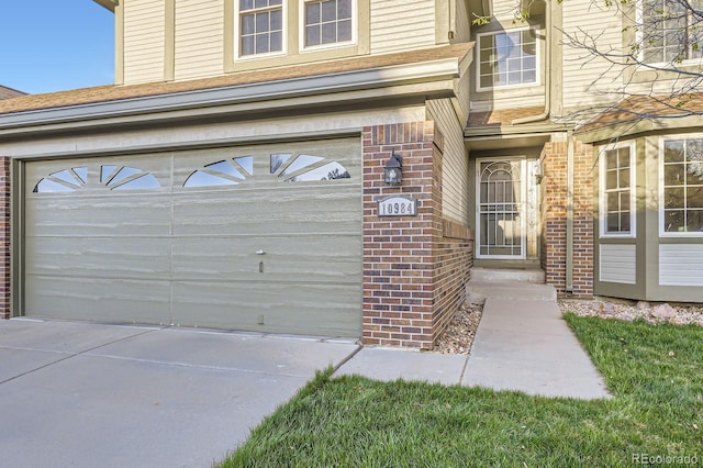 exterior space with brick siding, driveway, and a garage