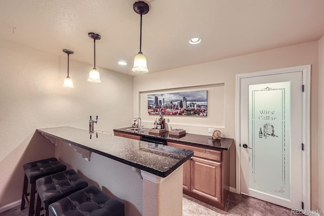 bar with decorative light fixtures, baseboards, a sink, and recessed lighting