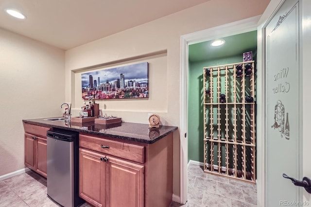interior space featuring recessed lighting, baseboards, indoor wet bar, and a sink