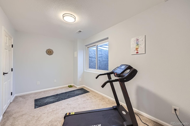 exercise room featuring carpet floors, a textured ceiling, visible vents, and baseboards