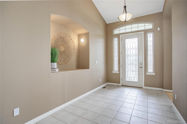 entryway with lofted ceiling, a healthy amount of sunlight, and light tile patterned flooring