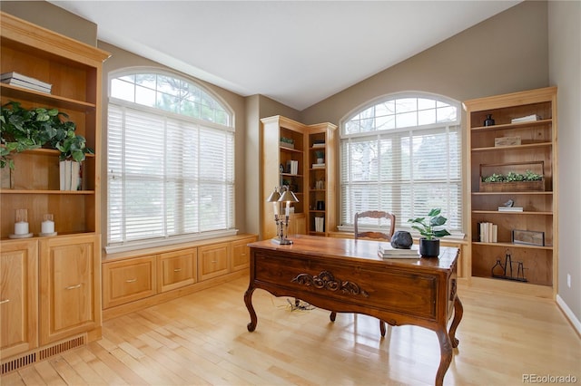 office area with a wealth of natural light, light wood-type flooring, and lofted ceiling