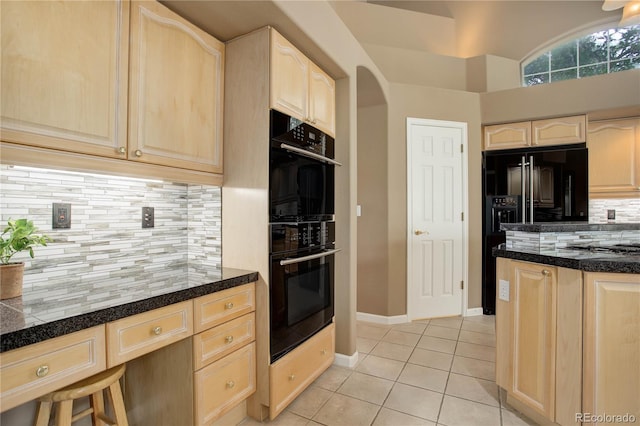 kitchen with light brown cabinets, black appliances, light tile patterned flooring, and backsplash