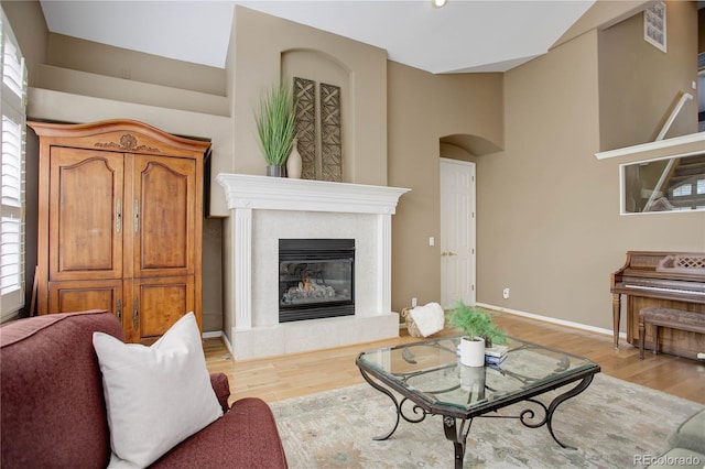 living room with a towering ceiling, light hardwood / wood-style floors, and plenty of natural light