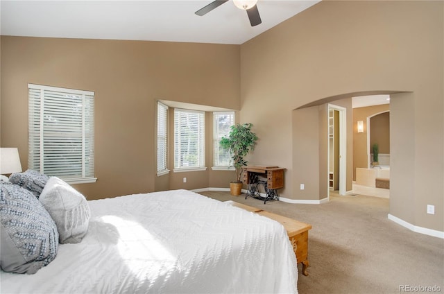 bedroom featuring high vaulted ceiling, light colored carpet, ceiling fan, and connected bathroom